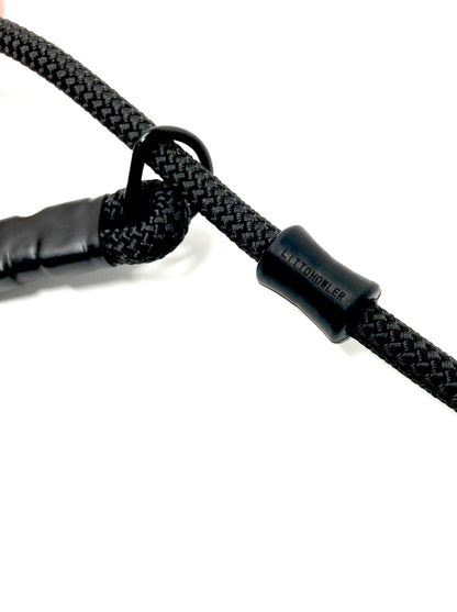 A close-up image of the metal d-ring and silicone stopper that has "Litto Howler" engraved.